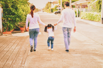Concept Family.Parents and daughters go for a walk in the park.Family is doing holiday activities.