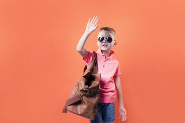 cute boy with a suitcase on a bright orange background