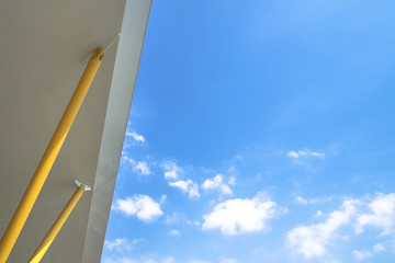 The roof with yellow pillars and blue sky with some cloud. Very suitable for use as background.