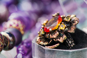 Macro shot of silver engagement ring in gift box on colorful, sparkling background. Ring made of yellow sapphire and citrine stone. Healing, natural crystals and powerful energy