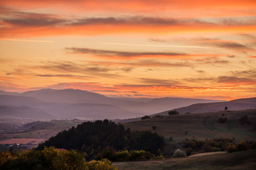 Romantic, bright and colorful sunset over a mountain range in Transilvania. Beautiful, colorful autumn background