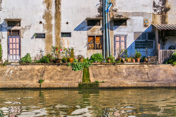 Fototapeta na wymiar Thai houses along Khlong Rob Krung Canal in Bangkok, Thailand