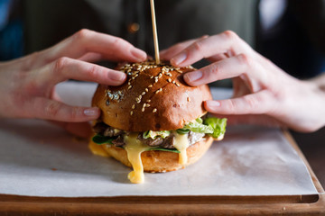 Woman's hands with hot burger. Fast food concept. Close up view.