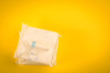 Sanitary pads and tampon on a yellow background. hygiene products