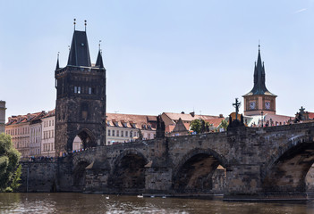 Tourists walk along the Charles Bridge on a summer sunny day. Pr