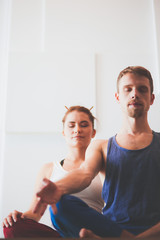 Fototapeta na wymiar Young healthy couple in yoga position on white background