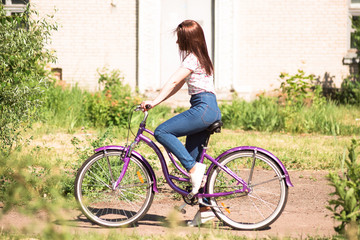 Obraz premium Happy pretty young girl bicycling on summer park. Happy relax time in city. Beautiful woman, sunny day