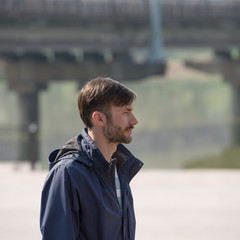 bearded man looks around in the city street.