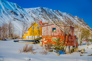 Fototapeta na wymiar Outdoor view of wooden houses partial covered with snow in Lofoten islands