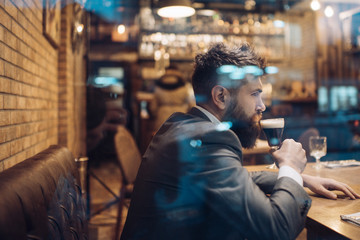 Bearded man rest in restaurant with beer glass. Businessman with long beard drink in cigar club....