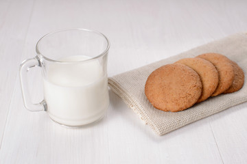 Homemade ginger cookies with a glass of milk on a wooden light b
