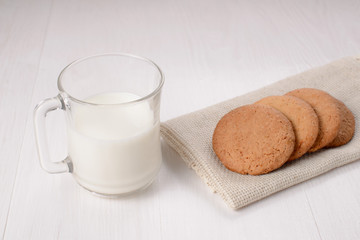 Homemade ginger cookies with a glass of milk on a wooden light b