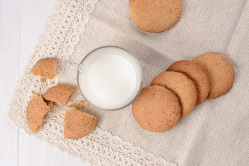 Homemade ginger cookies with a glass of milk on a wooden light b