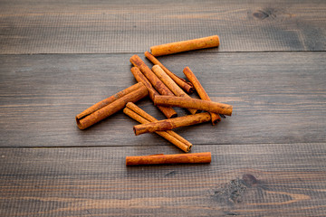 Cinnamon sticks on dark wooden background top view copy space. Condiment for mulled wine
