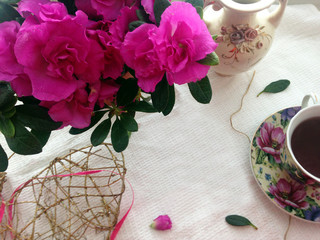 Morning breakfast with tea and pink azaleas flowers. Relax. Copy space.