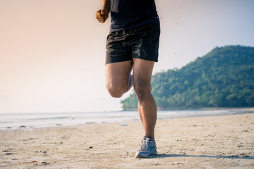 Athlete man runner legs running closeup on shoe,Men jogging on the beach 