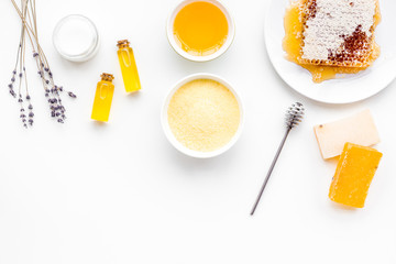 Homemade cosmetics with honey. Handmade soap, spa salt, cream on white background top view copy space