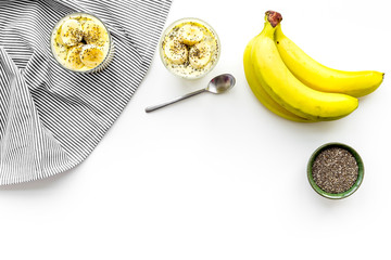 Light healthy snack. Banana pudding with chia seeds on white table with blue tablecloth top view space for text