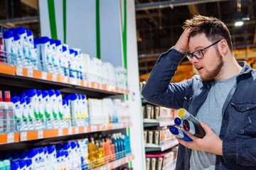 man can't decide in store what to buy. shopping concept. copy space