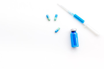 Medical therapy. Syringe, bottle with drug, pills on white background top view copy space