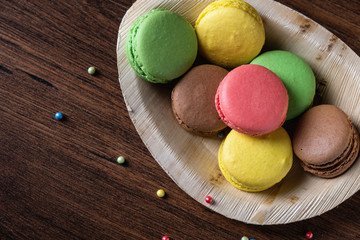 Colorful macarons on bamboo dish