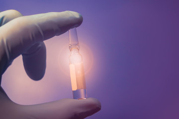 ampule in hand. on a tinted background. highlight.