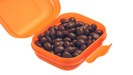 candy, chocolate-covered raisins in the orange box on white background