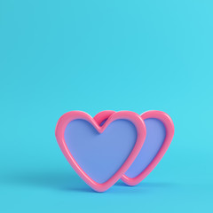 Two abstract pink hearts on bright blue background in pastel colors.