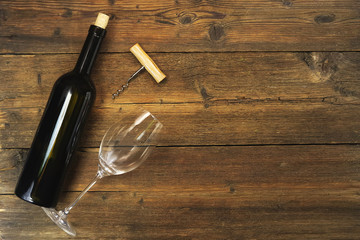 a bottle of wine and a wine glass on a wooden background