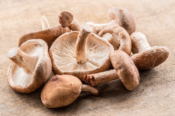 Shiitake mushrooms on the wooden background.