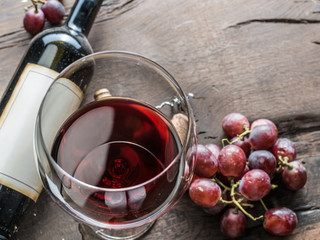 Wine glass, wine bottle and grapes on wooden background. Wine tasting.