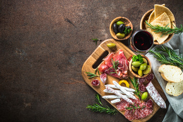 Antipasto - sliced meat, ham, salami, olives and glass wine