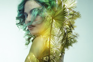 double exposure, beautiful woman with green hair fused with wild and tropical jungle