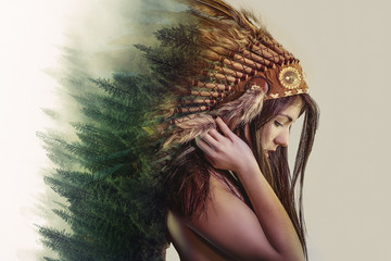 double exposure, beautiful woman with indian plume of plume and a forest on the head concept nature