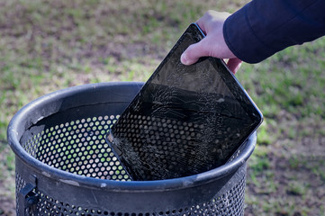 Man throws it in the trash modern tablet with highly broken screen.