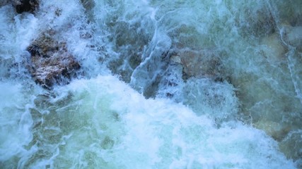 SLOW MOTION: flowing water over stones in mountain river