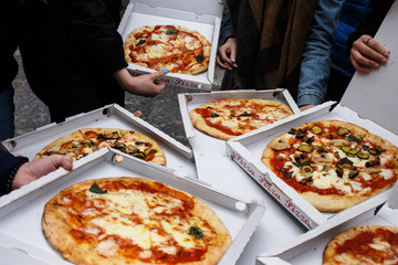 Overhead shot of friends at the street with take-away pizza, Naples