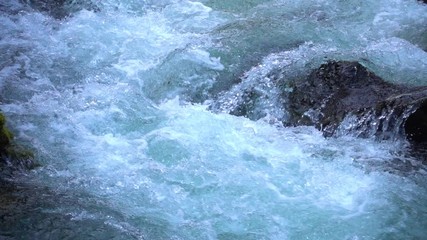 SLOW MOTION: flowing water over stones in mountain river