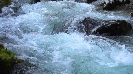 SLOW MOTION: flowing water over stones in mountain river