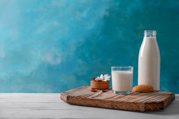 Composition with milk on table against color background