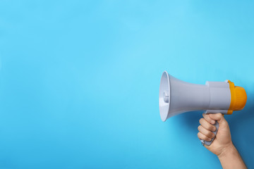 Man holding megaphone on color background