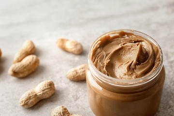Jar with creamy peanut butter, closeup