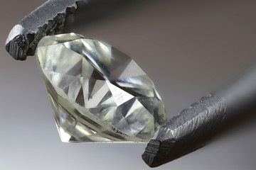 0.45 ct brilliant cut diamond held by tweezers