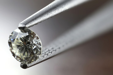 0.45 ct brilliant cut diamond held by tweezers