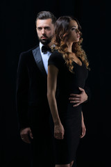 man next to woman posing in studio