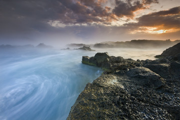 Breathtaking ocean sunset / Water whirlpool on amazing volcanic coast of south Iceland 