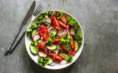 Fototapeta na wymiar Salad with fresh spring vegetables