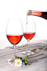 Waiter pouring of wine, rose wine served with two glasses and flowers copy space close up