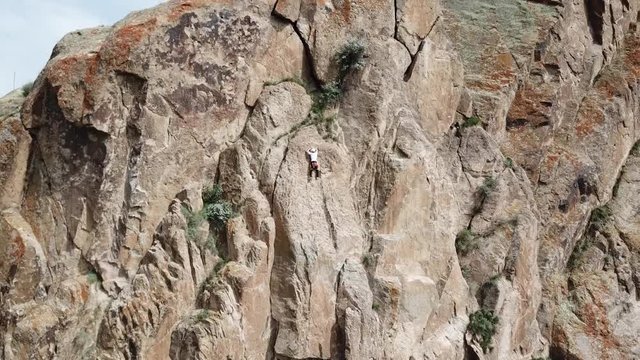 Climber. Climb up the rock. Shooting from the air. Aerial photography. Extreme, active rest, freedom. Beautiful nature, rock, wall, greenery. Professional. Sky. Kazakhstan, Tamgaly Tas 15 April 2018.