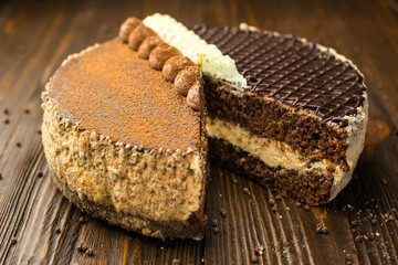 Dark chocolate vegan cake with candies and nuts on wooden background